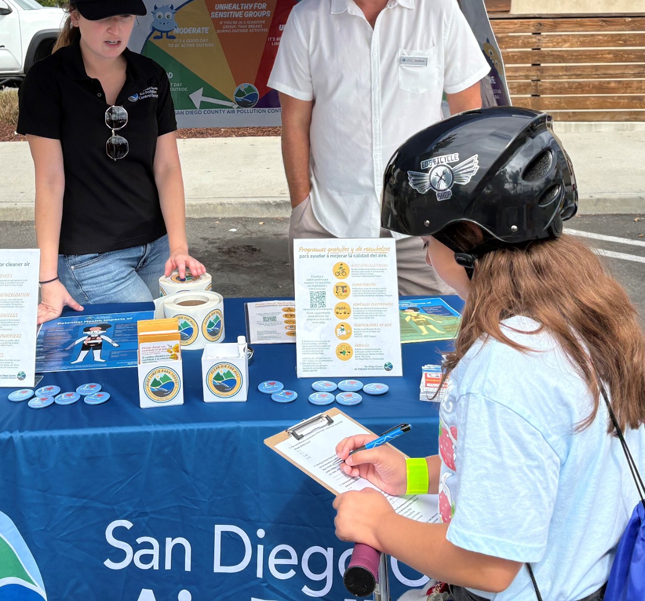 Two people install an air quality monitor. 